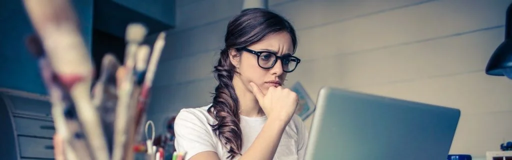 Aselecte steekproeftrekking afbeelding - Vrouw denkend achter laptop